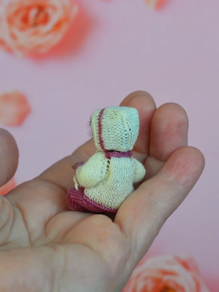 Miniature doll child in 12th scales. A baby for the dollhouse. Baby in a knitted suit.