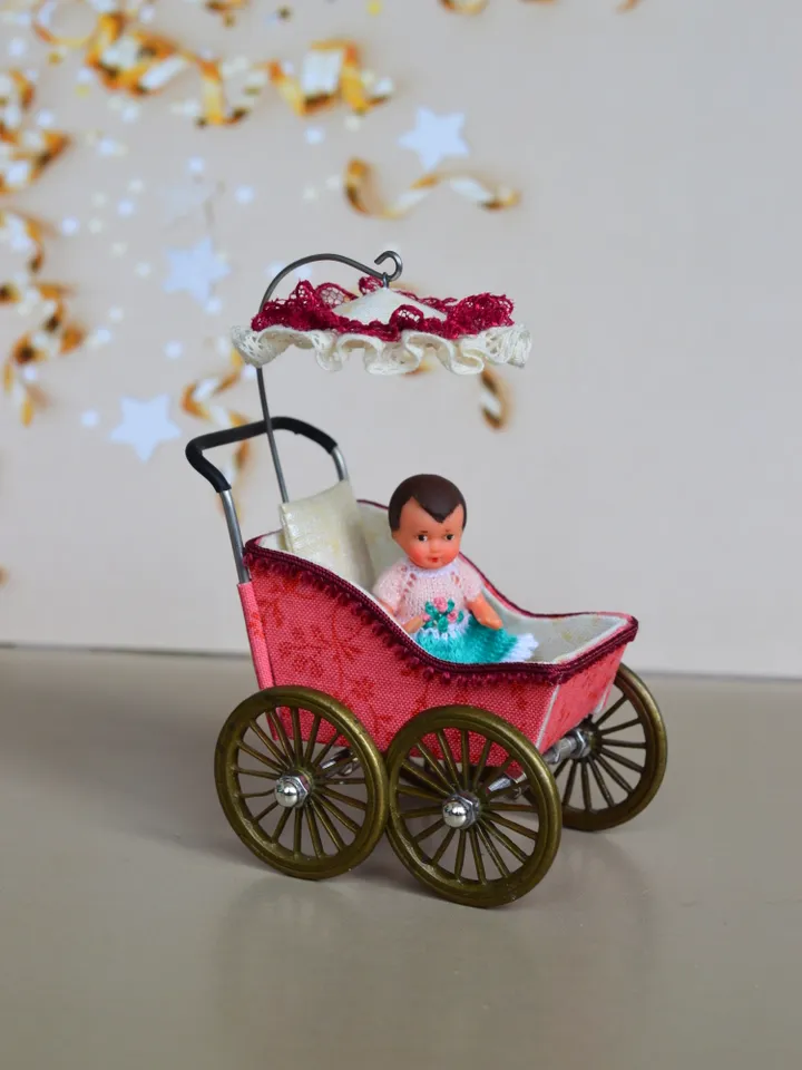 Miniature toy stroller for a little doll. Pram for the little poopsie.