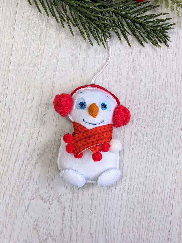 Cute felt snowman. Snowman with blue eyes and red scarf