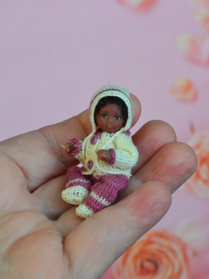 Miniature doll child in 12th scales. A baby for the dollhouse. Baby in a knitted suit.