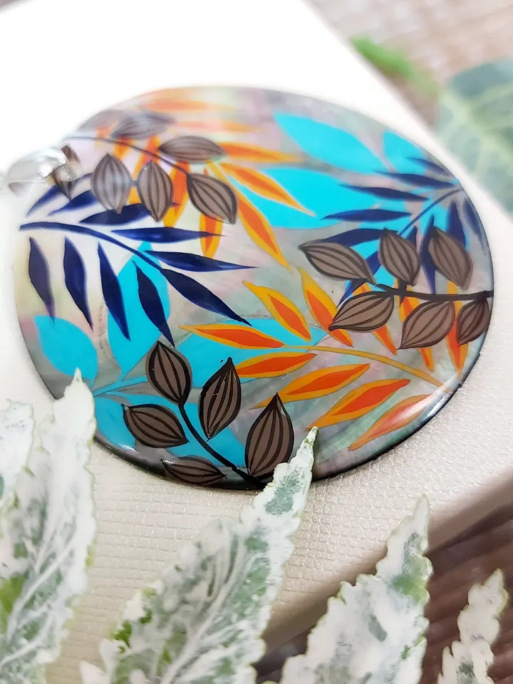 Artistic Expression in Nacre: Abstract Botanical Hand-Painted Mother-of-Pearl Pendant - Captivating Blue and Orange Leaf Motif