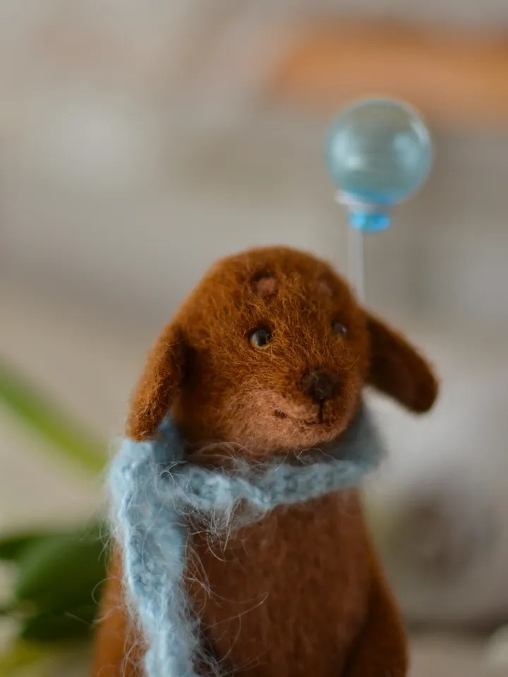 Handmade toy. Dachshund puppy in a scarf, with ice cream and a ball