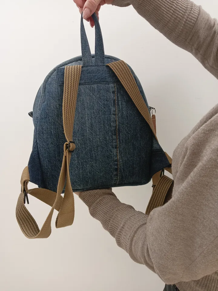 medium sized denim backpack made from recycled jeans for walking, studying, work, traveling. Backpack with 2 pockets outside and 3 pockets inside (1 with a zipper). Inside lining made of 100% cotton. Decorated with a label and a leather strip on the zippe