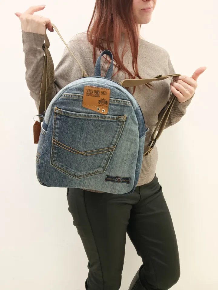 medium sized denim backpack made from recycled jeans for walking, studying, work, traveling. Backpack with 2 pockets outside and 3 pockets inside (1 with a zipper). Inside lining made of 100% cotton. Decorated with a label and a leather strip on the zippe