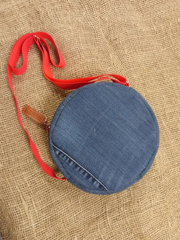 Cute round denim handbag with 5 pockets, adjustable strap and polka dot cotton inside.