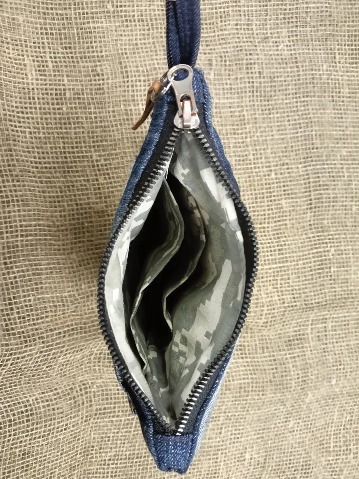 A small denim clutch bag , recycled jeans purse, closes with a zipper, 3 functional jeans pockets on the outside, cotton and 2 pockets on the inside.