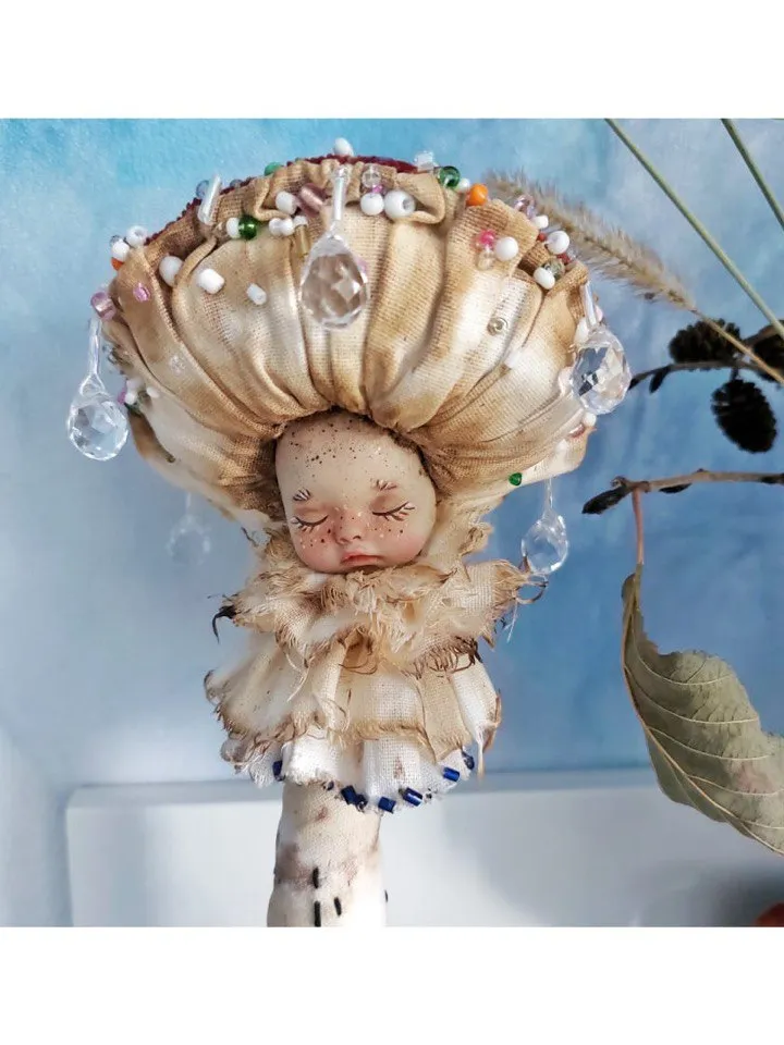 Art doll Mushroom. Unusual handmade figurine. Sleeping child-toy in the image of a fly mushroom. Unique statuette is made of fabric and polymer clay, decorated with beads and beads. An art object for your interior and collection