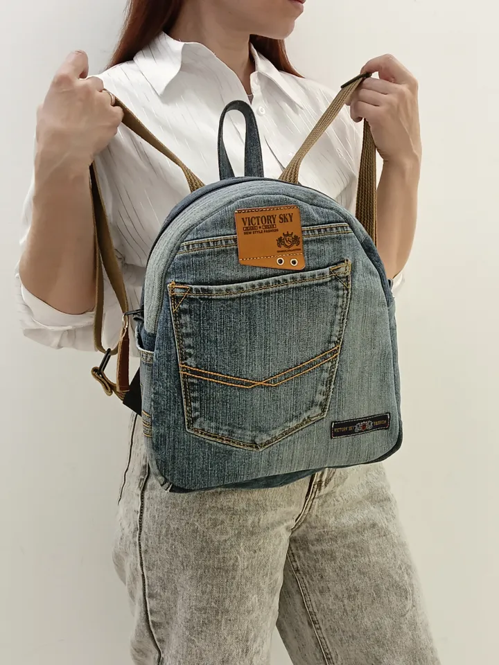 medium sized denim backpack made from recycled jeans for walking, studying, work, traveling. Backpack with 2 pockets outside and 3 pockets inside (1 with a zipper). Inside lining made of 100% cotton. Decorated with a label and a leather strip on the zippe