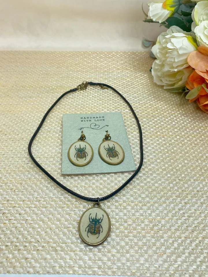 A set of jewelry with the image of beetles. Individual design.