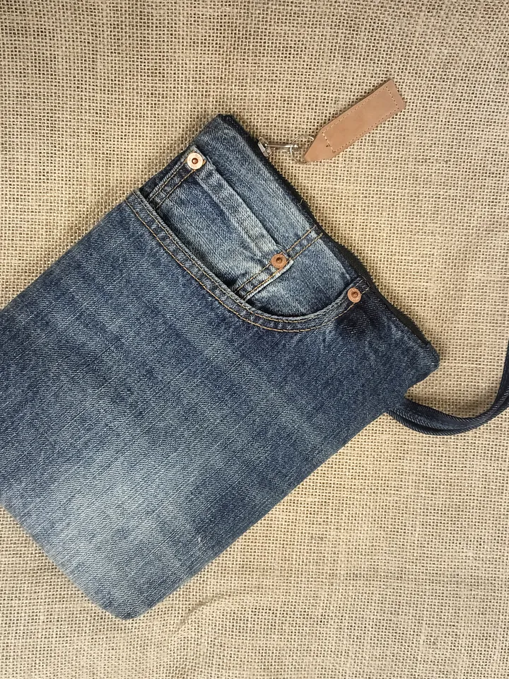 A small denim clutch bag , recycled jeans purse, closes with a zipper, 3 functional jeans pockets on the outside, cotton and 2 pockets on the inside.