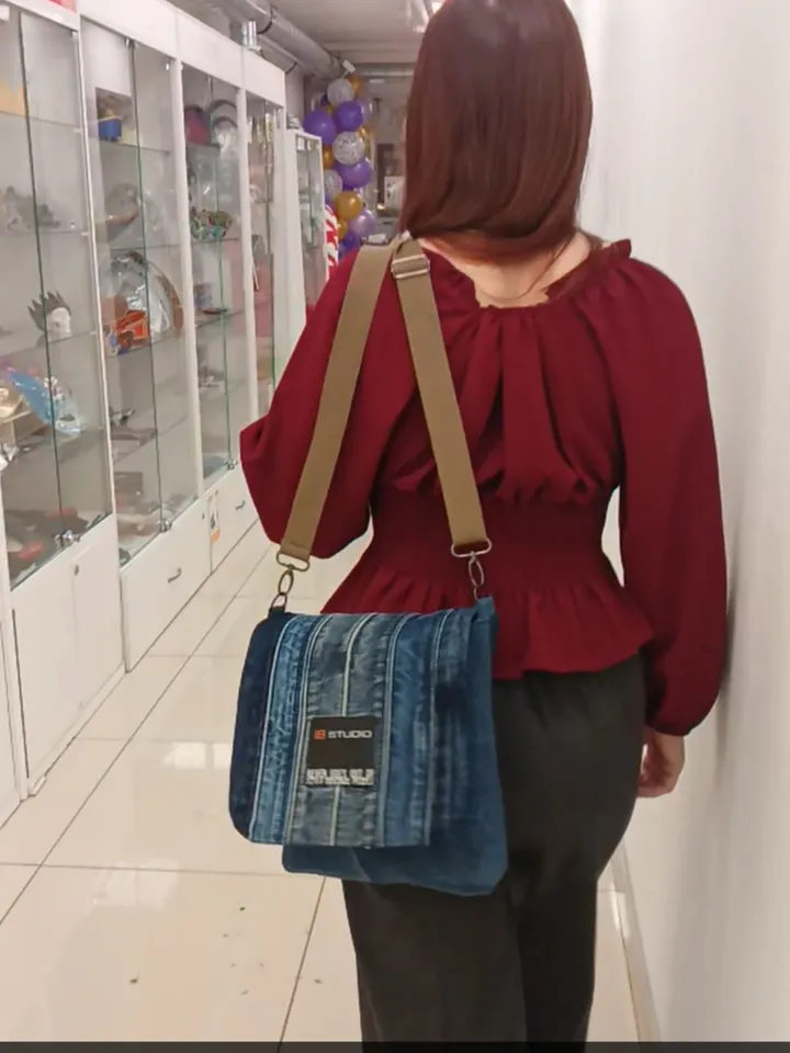 Denim messenger bag made of denim fabric with a denim belt flap. It has an external pocket on the back wall, 3 internal pockets and a patterned cotton lining.
