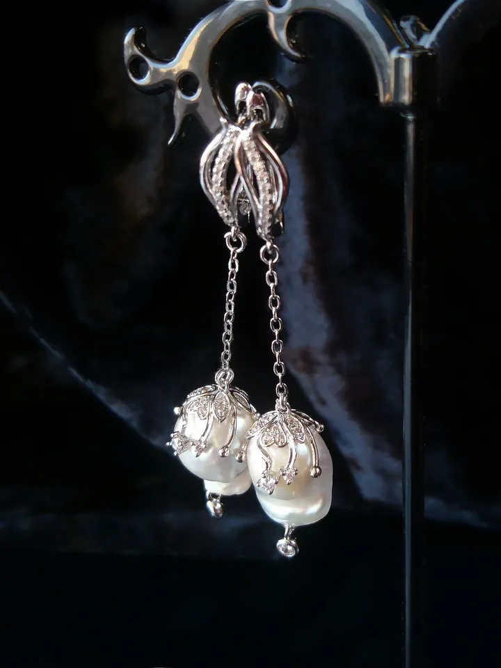 Earrings with baroque pearls and circus pendants on chains