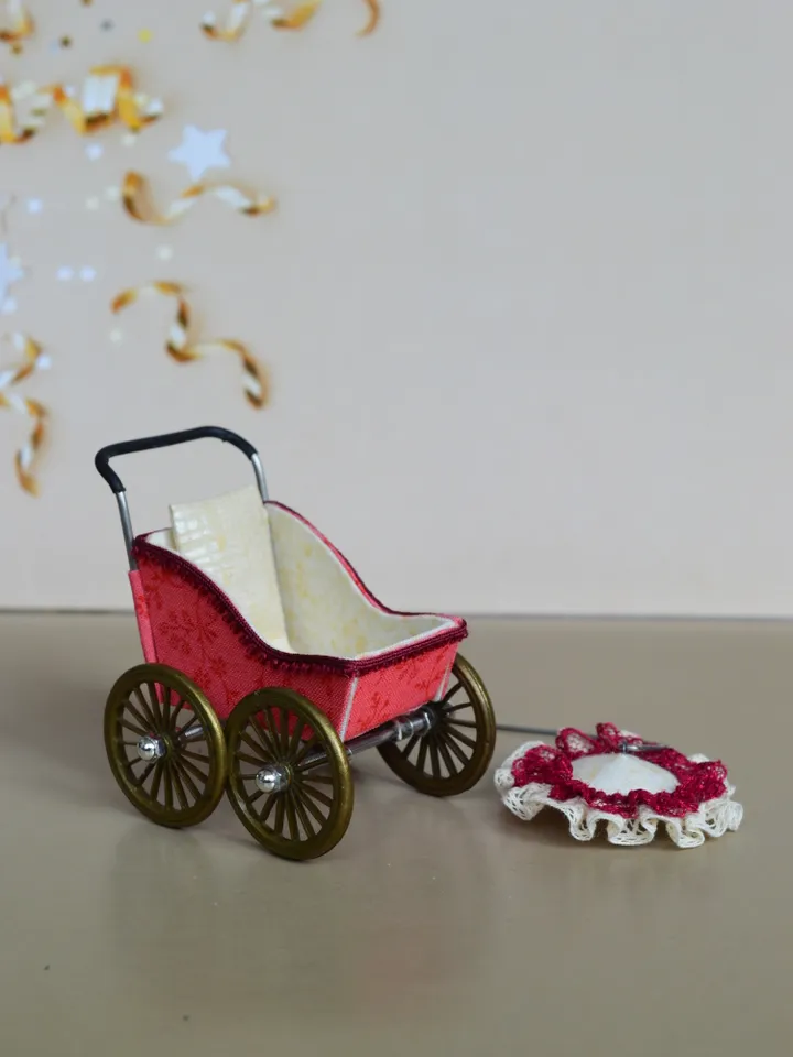 Miniature toy stroller for a little doll. Pram for the little poopsie.