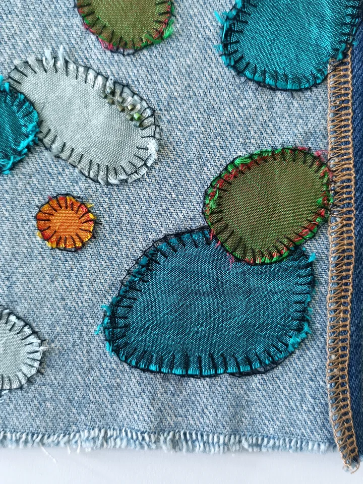 Upcycled denim/silk boro patch – visible mending.