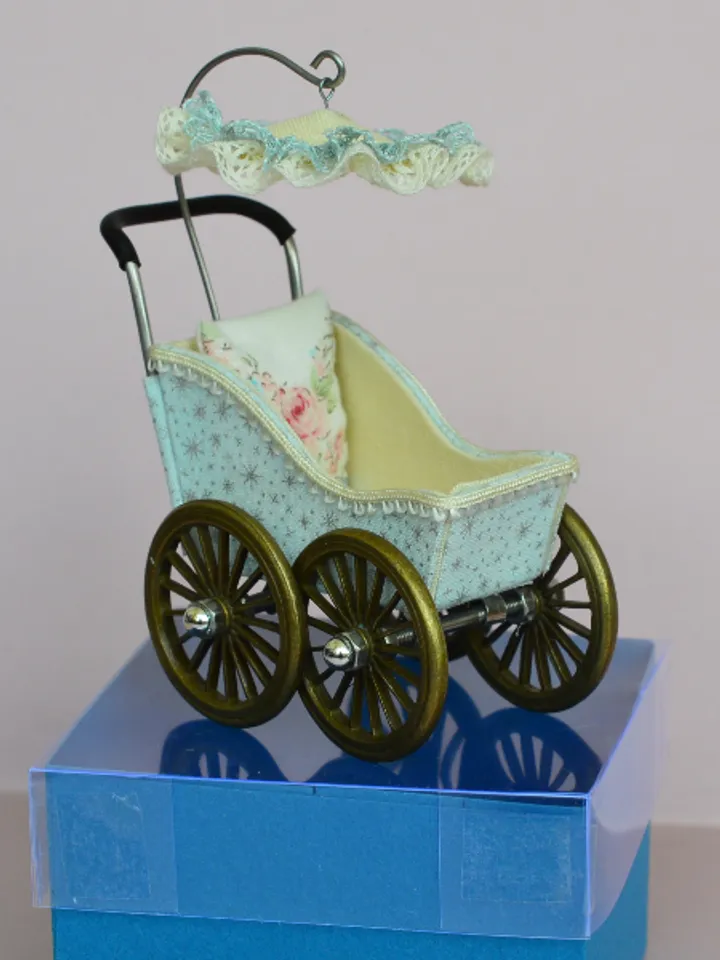 Miniature toy stroller for a little doll. Pram for the little poopsie.