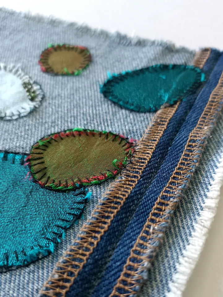 Upcycled denim/silk boro patch – visible mending.