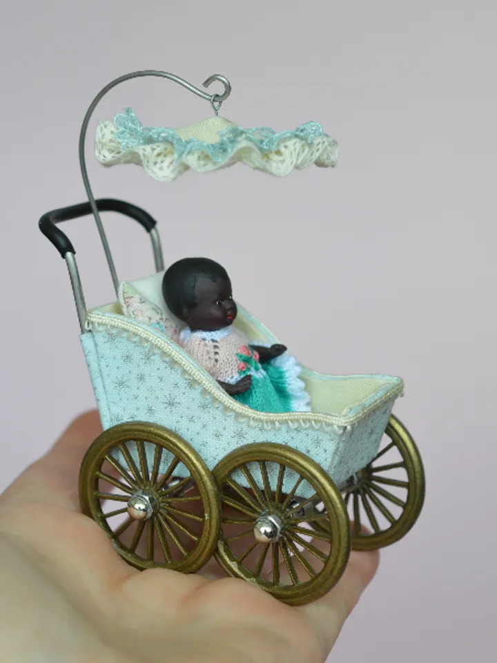 Miniature toy stroller for a little doll. Pram for the little poopsie.