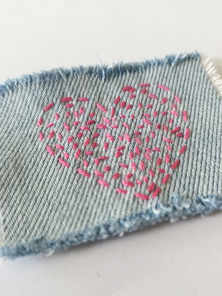 Denim patch hand sewn from recycled fabric.