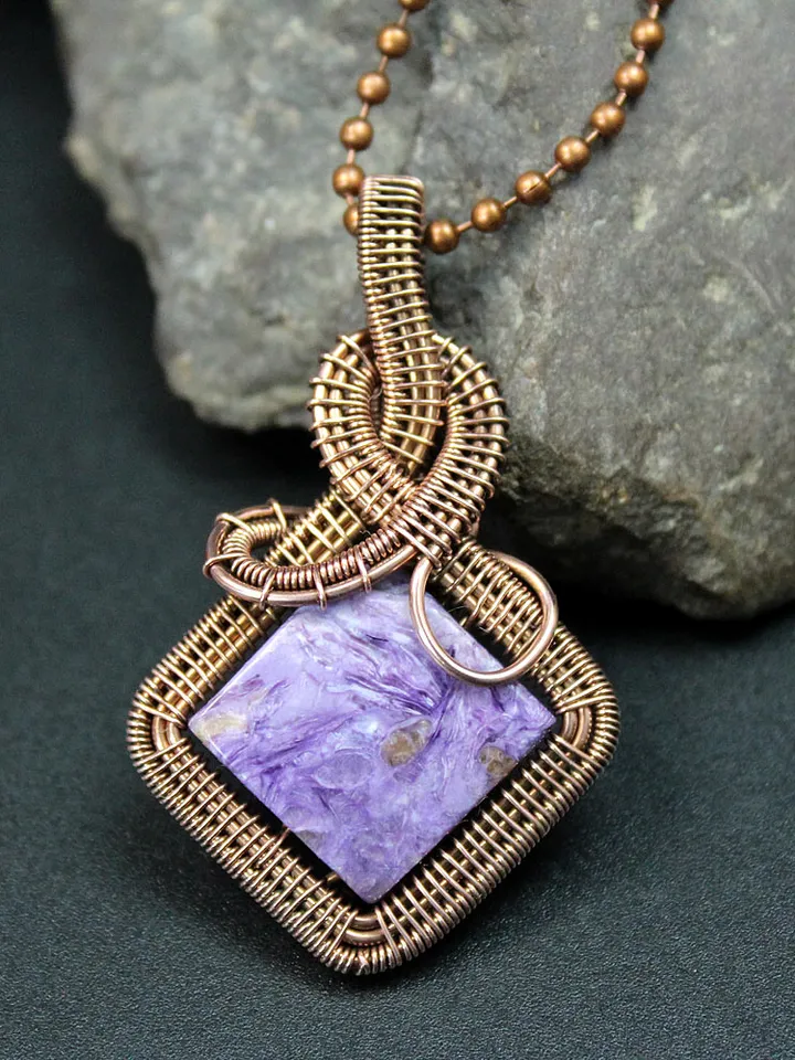 Handmade pendant of natural charoite and copper wire.