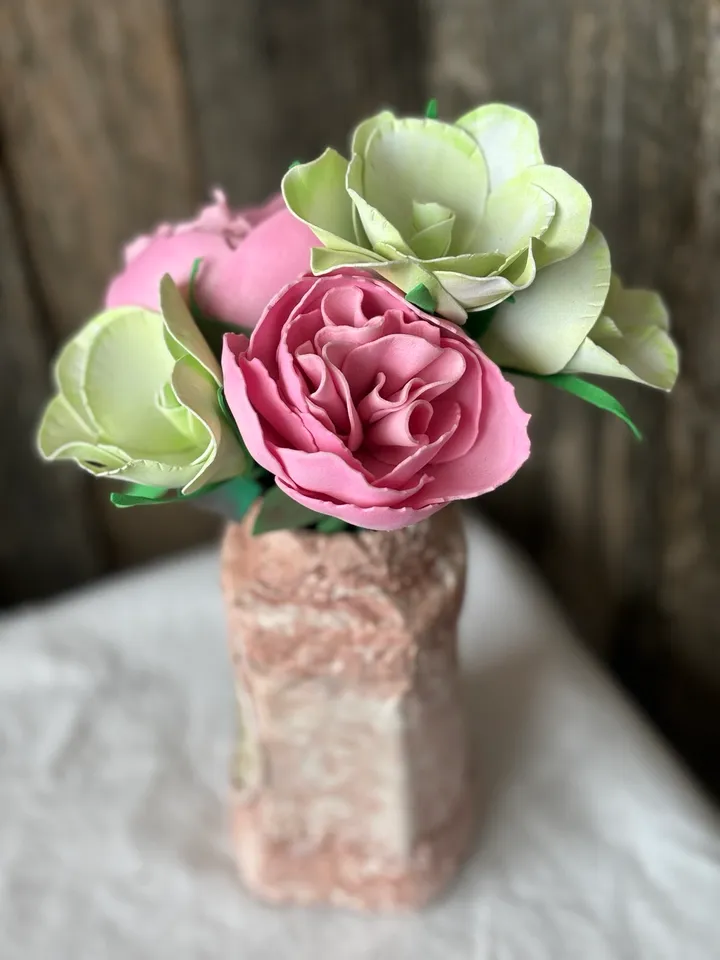 Delicate composition of pink peonies and eustomes in a handmade vases