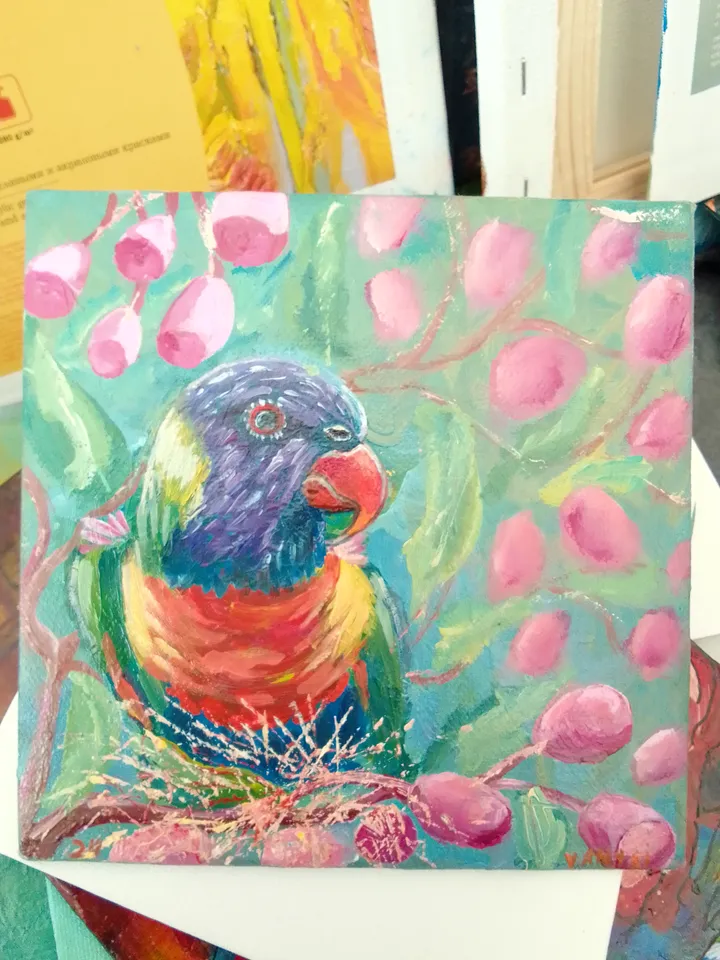 Parrot sits on a branch of a flowering tree