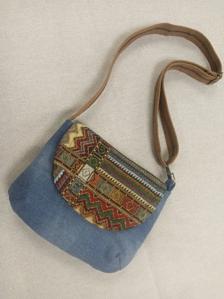 A small crossbody bag, a women's messenger bag with a tapestry flap, a denim shoulder bag with pockets inside and an adjustable strap