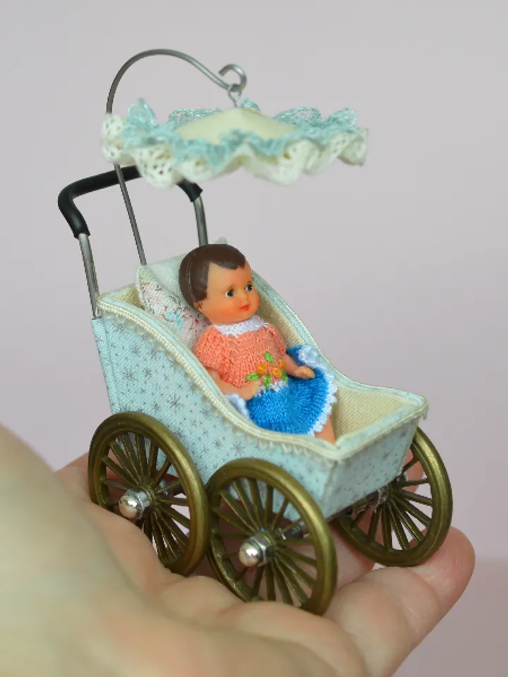 Miniature toy stroller for a little doll. Pram for the little poopsie.