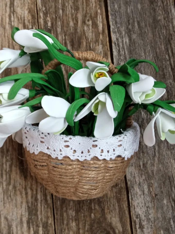 A bouquet of delicate handmade snowdrops in a basket.