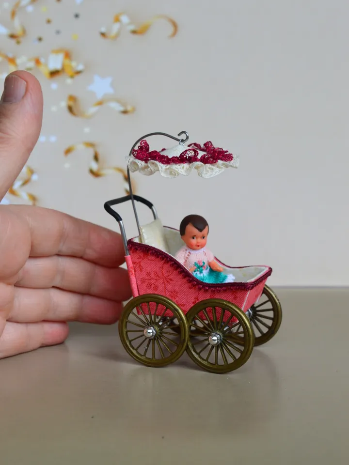 Miniature toy stroller for a little doll. Pram for the little poopsie.