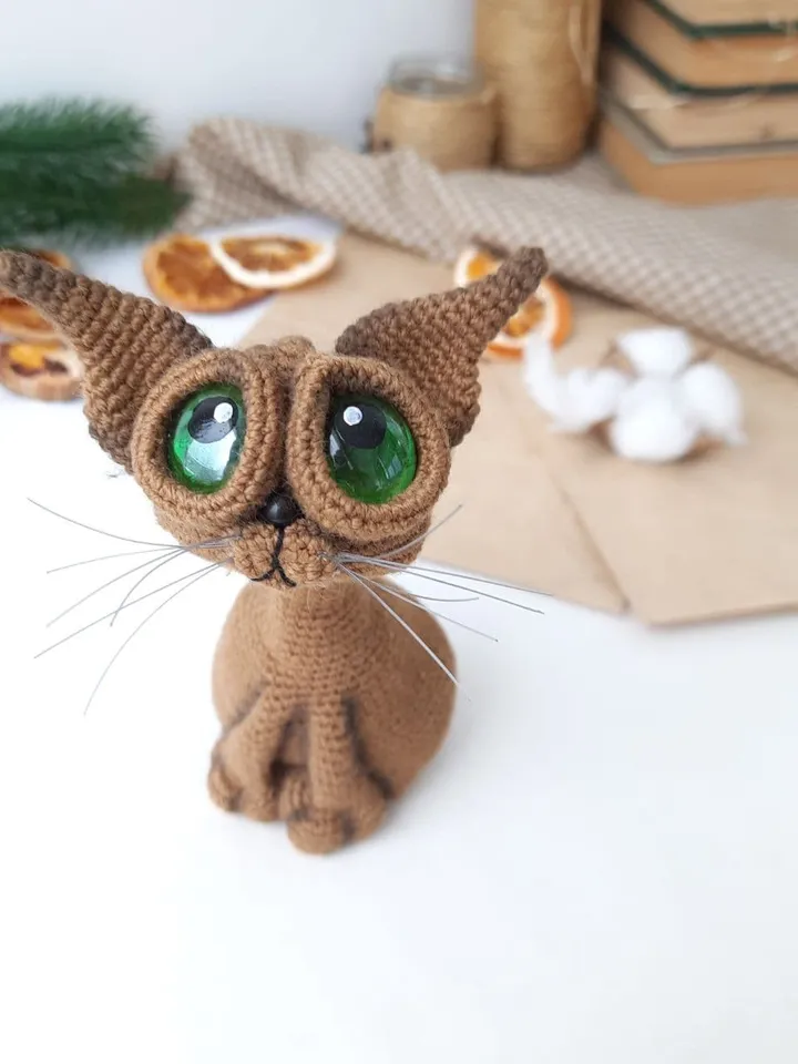 Crochet sculpture of a graceful brown cat with green eyes. Big-eyed cat as a gift for cat lovers.