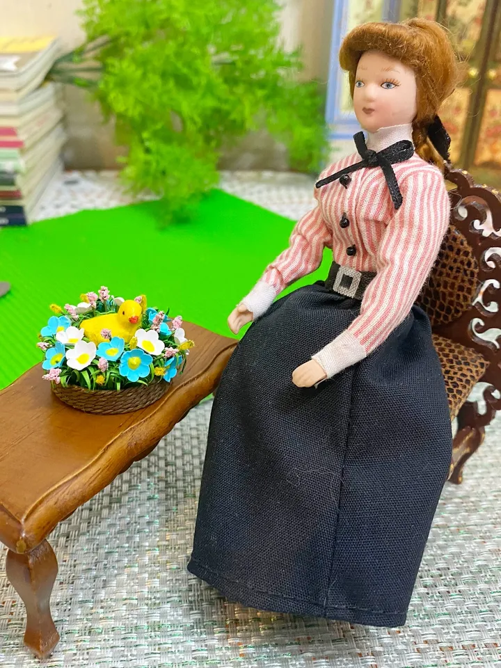 Easter miniature.Chicken in a basket with flowers.
