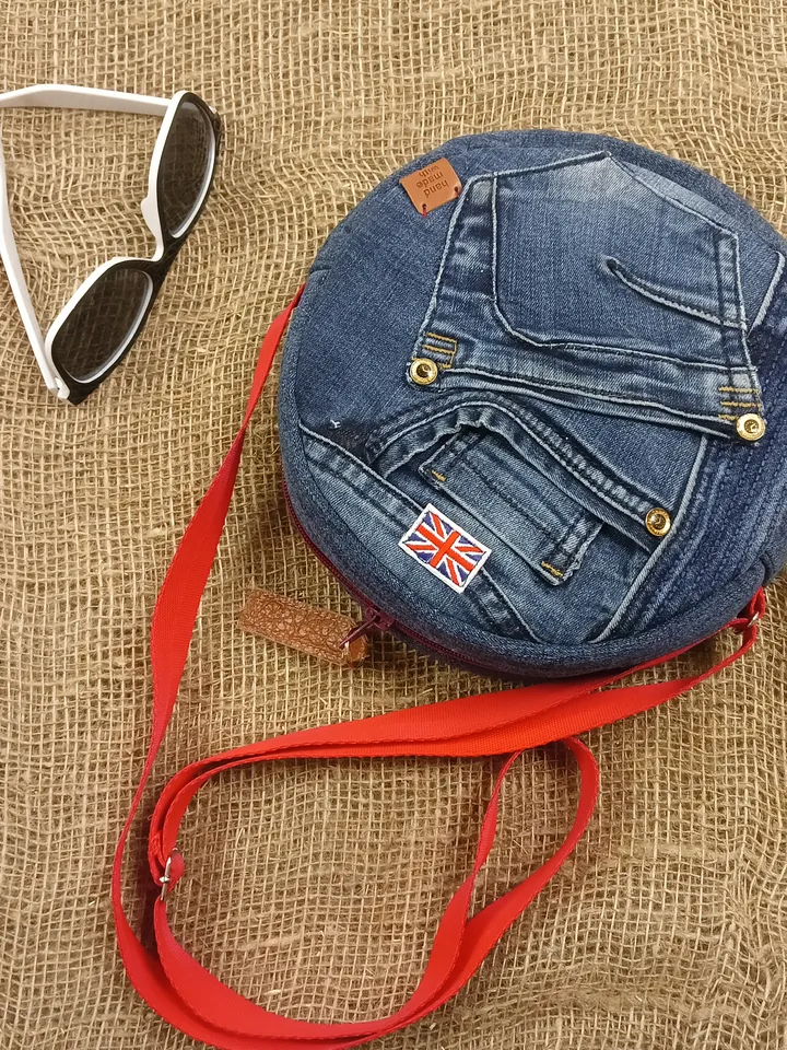 Cute round denim handbag with 5 pockets, adjustable strap and polka dot cotton inside.