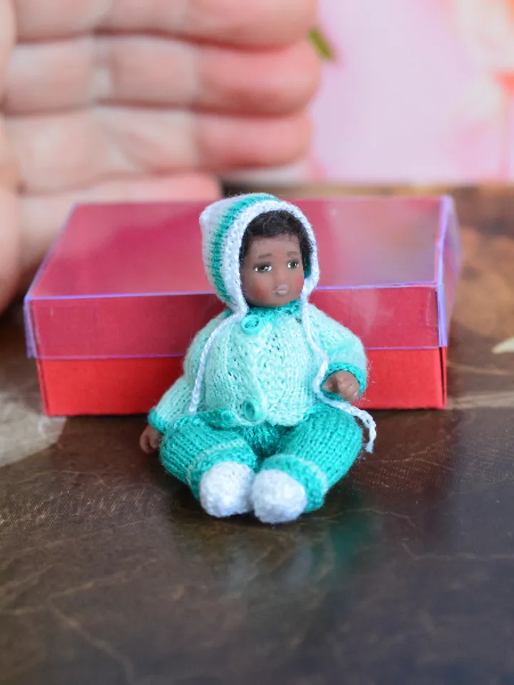 Miniature doll child in 12th scales. A baby for the dollhouse. Baby in a blue suit.