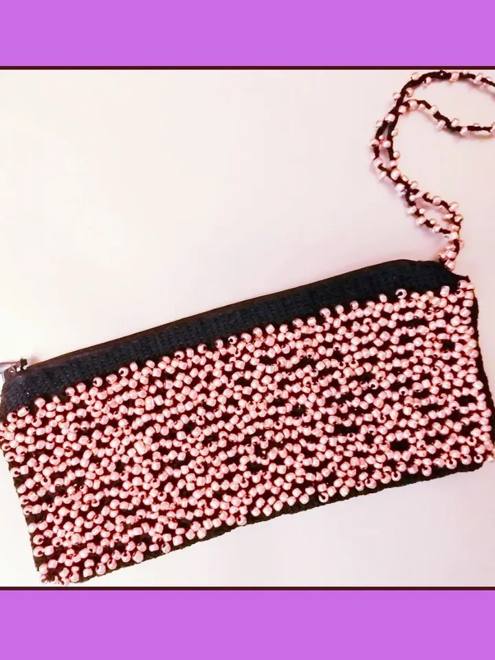 Pattern handbag with beads woven on bobbins. Fashionable accessory.