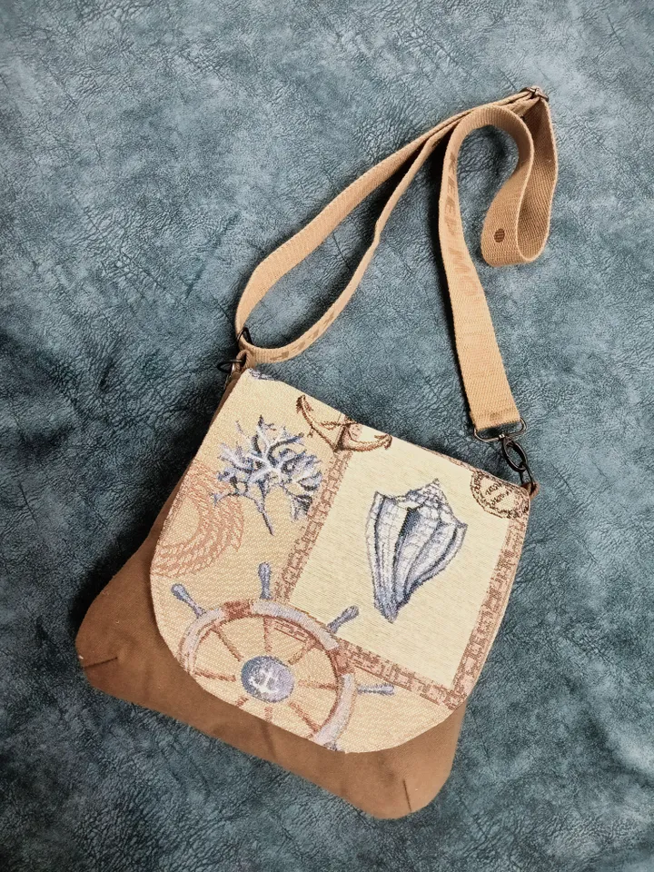 Denim handbag features a marine-style tapestry flap, cotton lining and 4 pockets inside. The strap on the carabiners is adjustable up to 123 cm /48,4". The size of the handbag is approximately 26cm/10,2"*23 cm/9", magnetic button closure. The weight is