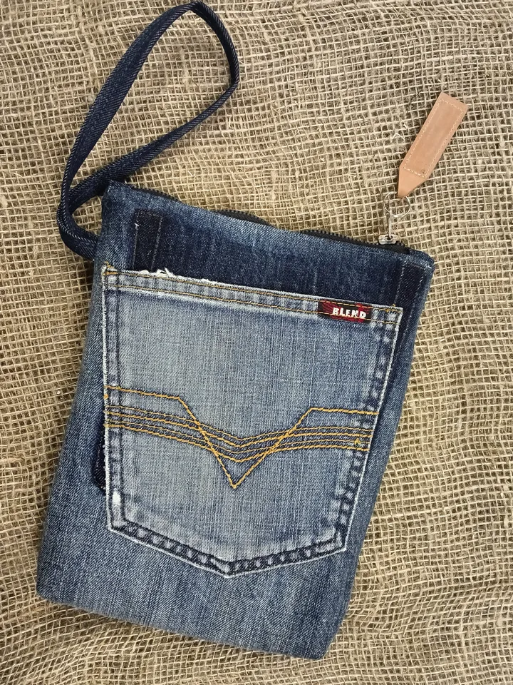 A small denim clutch bag , recycled jeans purse, closes with a zipper, 3 functional jeans pockets on the outside, cotton and 2 pockets on the inside.