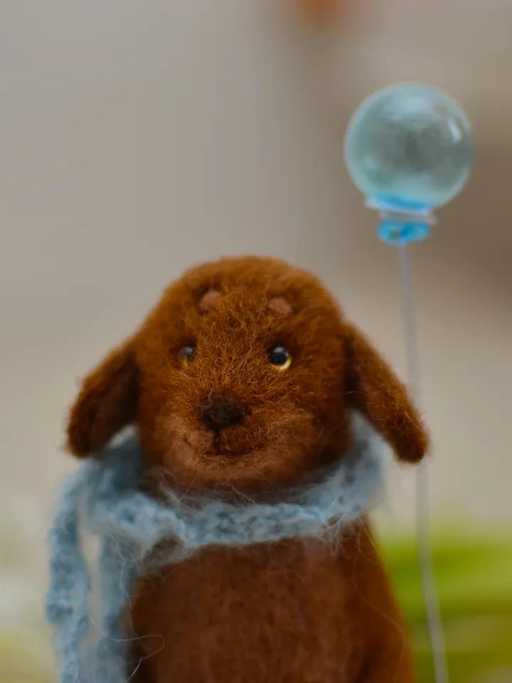 Handmade toy. Dachshund puppy in a scarf, with ice cream and a ball