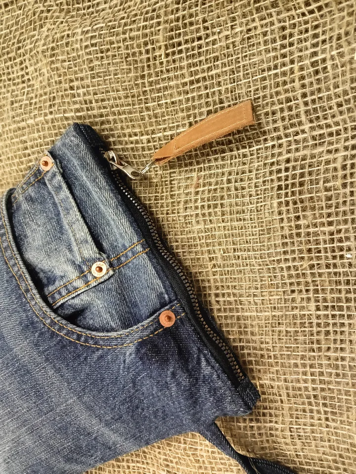 A small denim clutch bag , recycled jeans purse, closes with a zipper, 3 functional jeans pockets on the outside, cotton and 2 pockets on the inside.