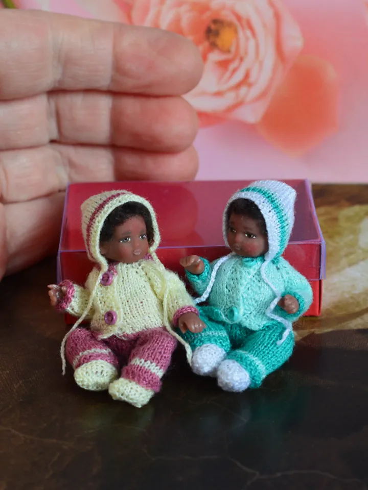 Miniature doll child in 12th scales. A baby for the dollhouse. Baby in a knitted suit.