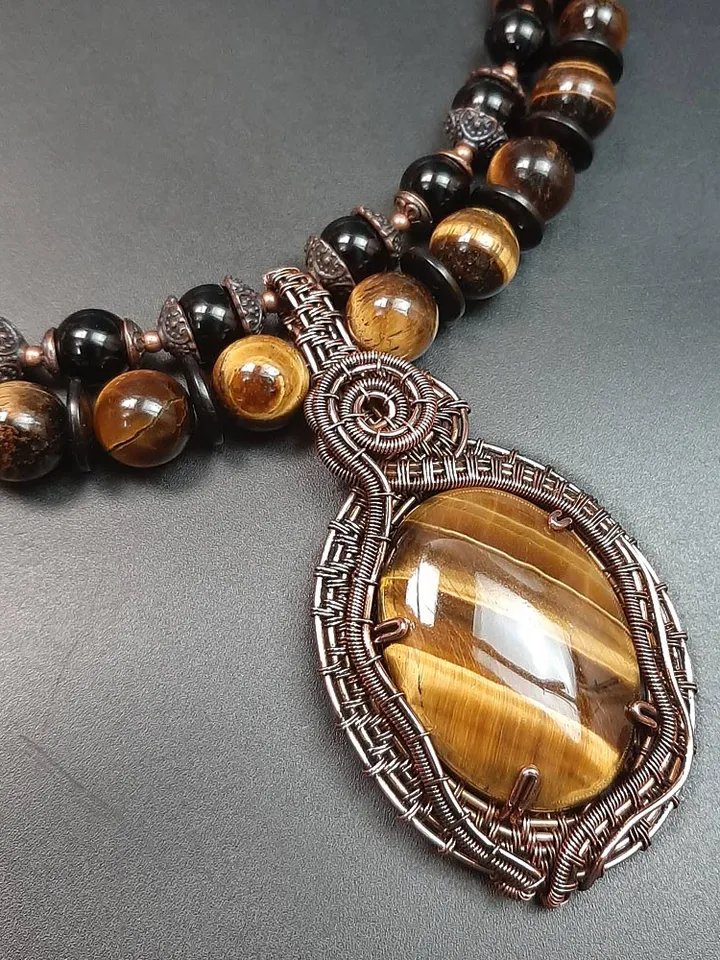 Handmade pendant made of Tiger Eye stone and copper wire.
