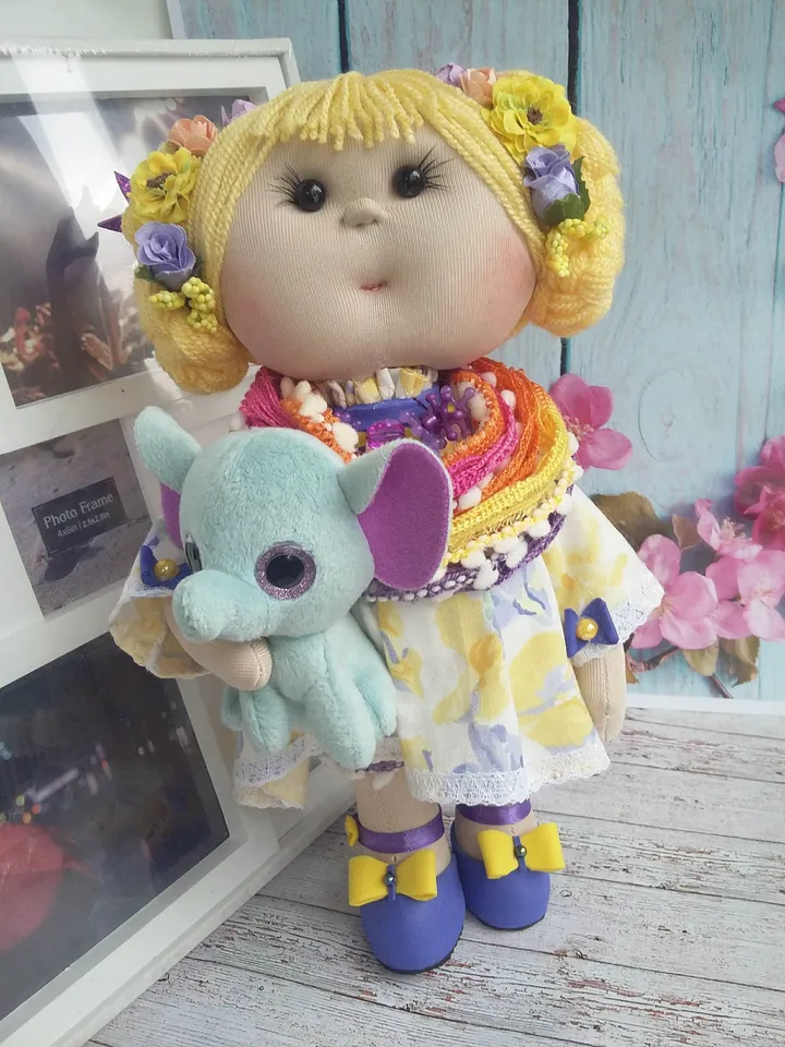 Doll Princess in the crown with an elephant in her hands, with yellow hair, beautiful, interior, birthday present, holiday