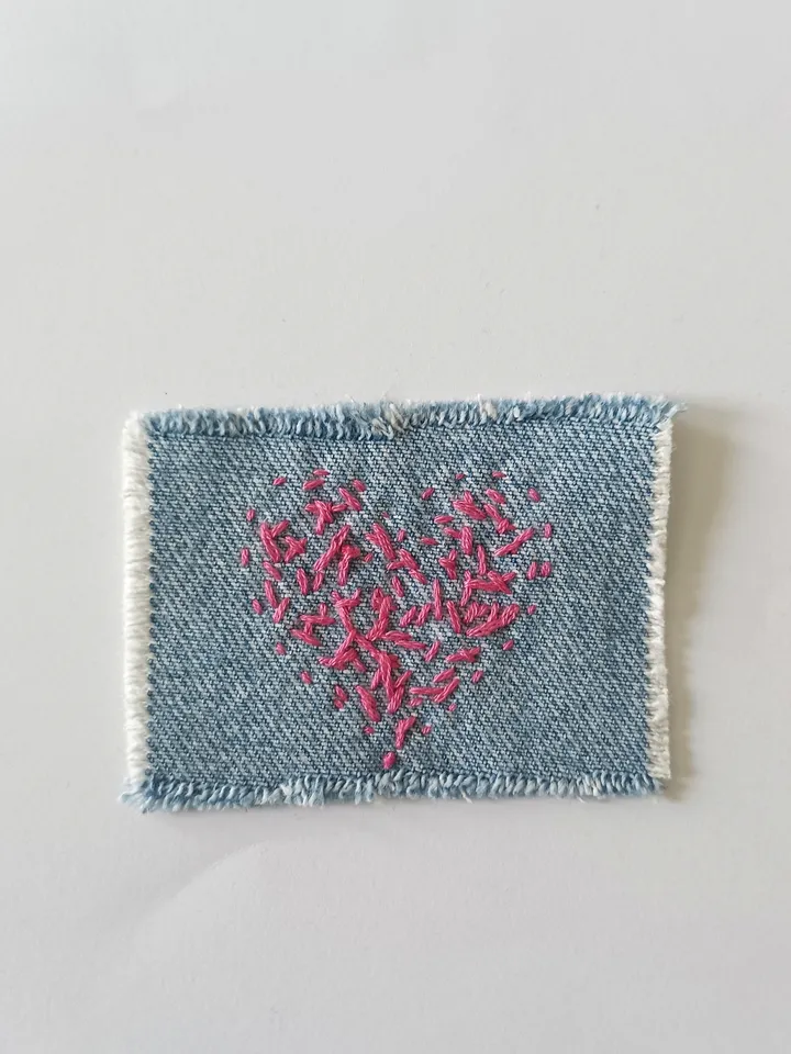 Denim patch hand sewn from recycled fabric.