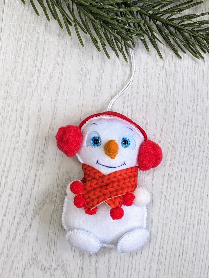 Cute felt snowman. Snowman with blue eyes and red scarf