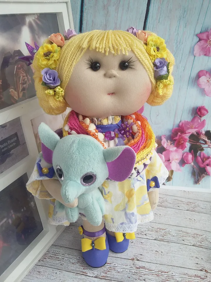 Doll Princess in the crown with an elephant in her hands, with yellow hair, beautiful, interior, birthday present, holiday