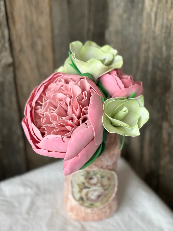 Delicate composition of pink peonies and eustomes in a handmade vases