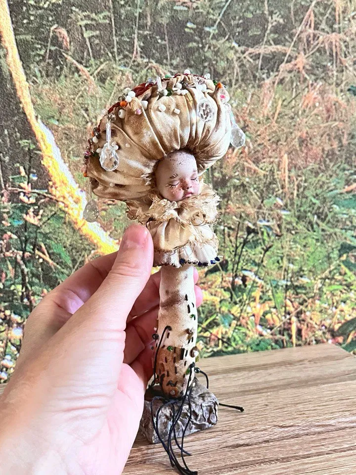 Art doll Mushroom. Unusual handmade figurine. Sleeping child-toy in the image of a fly mushroom. Unique statuette is made of fabric and polymer clay, decorated with beads and beads. An art object for your interior and collection