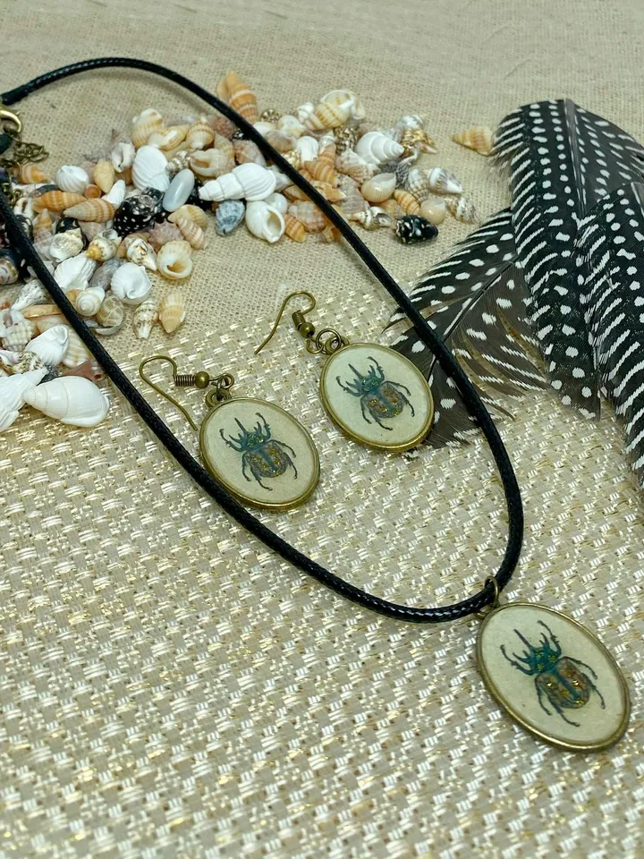 A set of jewelry with the image of beetles. Individual design.