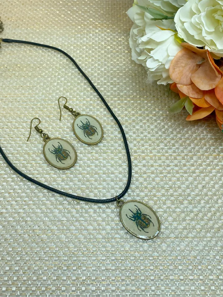 A set of jewelry with the image of beetles. Individual design.