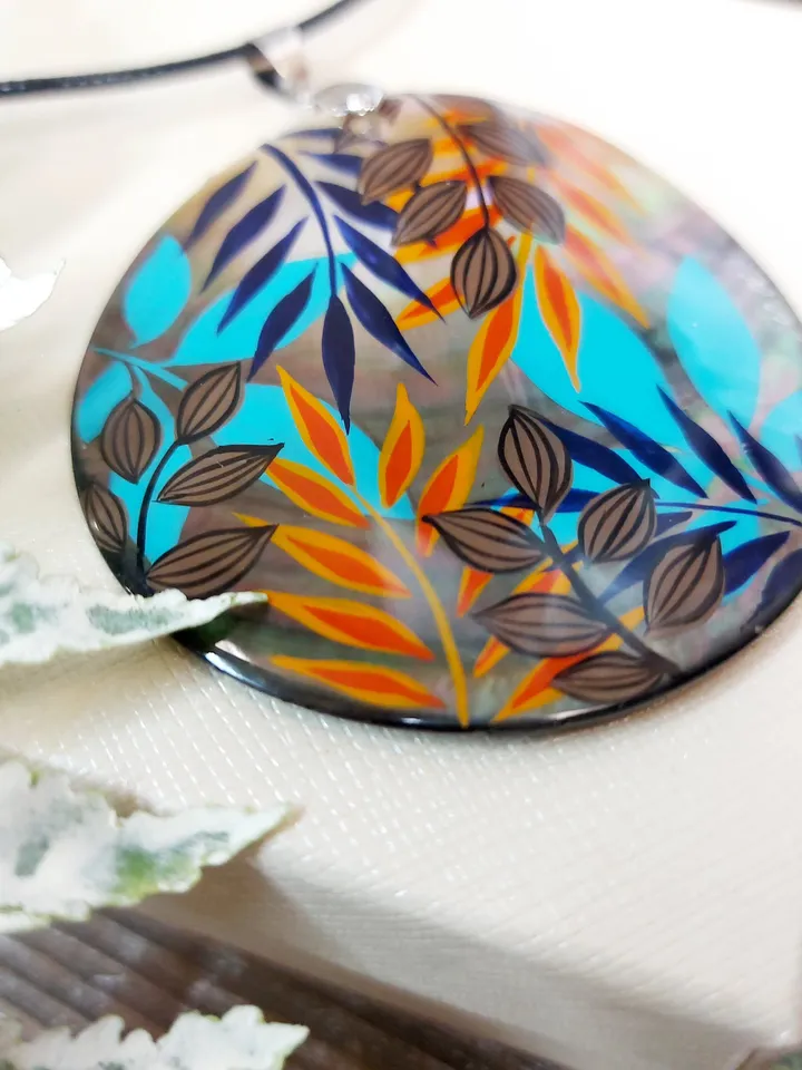 Artistic Expression in Nacre: Abstract Botanical Hand-Painted Mother-of-Pearl Pendant - Captivating Blue and Orange Leaf Motif