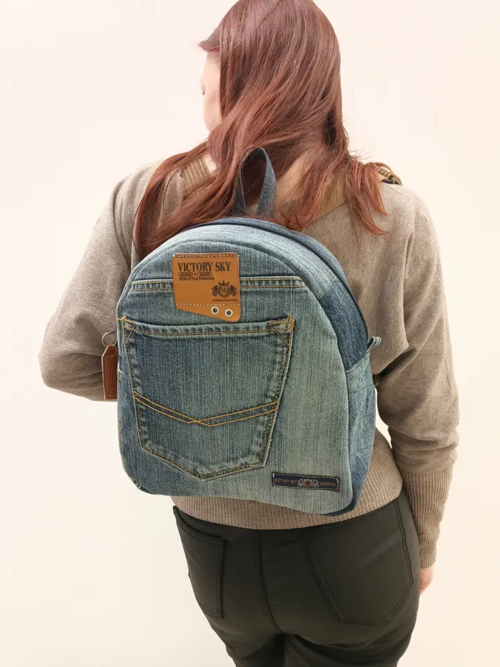 medium sized denim backpack made from recycled jeans for walking, studying, work, traveling. Backpack with 2 pockets outside and 3 pockets inside (1 with a zipper). Inside lining made of 100% cotton. Decorated with a label and a leather strip on the zippe